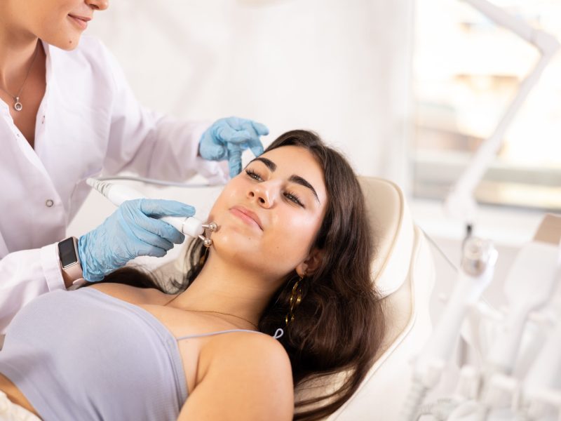 Attractive young girl undergoing radiofrequency skin tightening procedure enhancing facial skin tone and preventing wrinkles. Modern technologies in cosmetology and aesthetic medicine